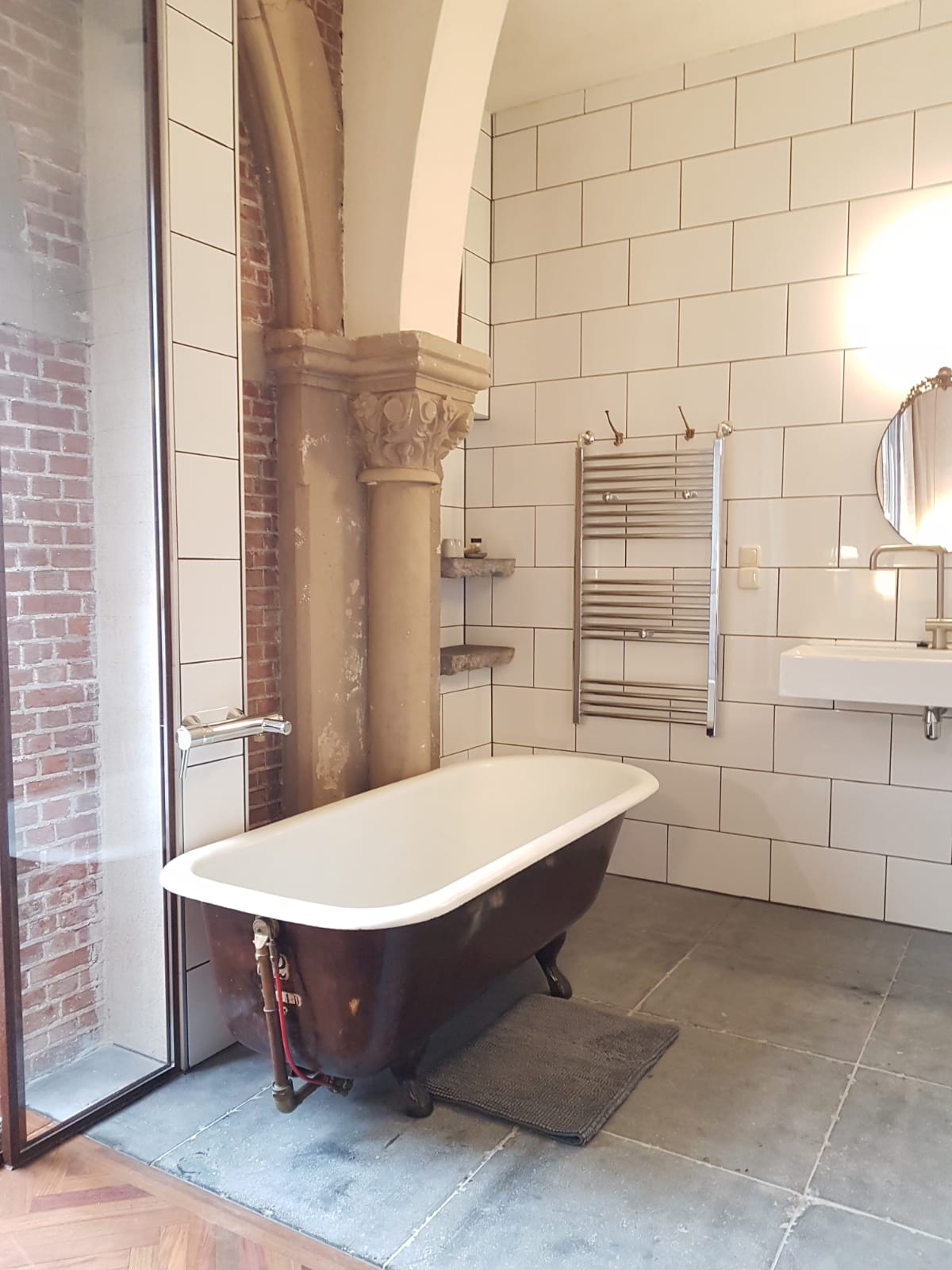 een prachtig oud gietijzeren bad (met erg heet water :) ) in een badkamer met originele elementen van de kerk,
 naast de kerkramen.